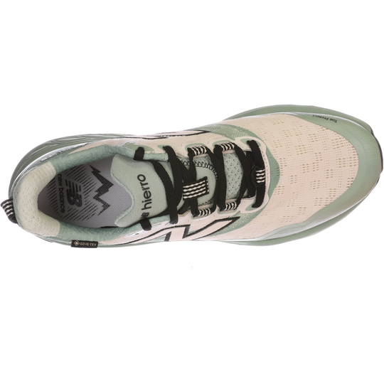 Green and beige running shoe with black laces on a white background
