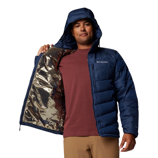 Man wearing a blue puffer jacket with a reflective lining, standing against a white background.