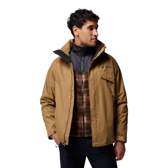 Man wearing a brown jacket with a plaid shirt underneath on a white background
