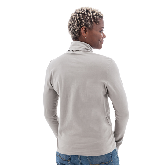 Person wearing a light gray turtleneck sweater on a white background