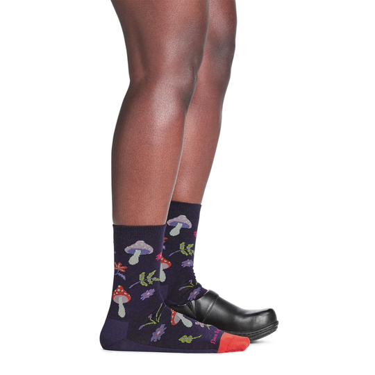 Black crew socks with colorful mushroom and flower pattern, worn with black shoes