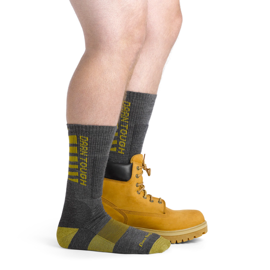 Gray socks with yellow accents worn with yellow boots on a white background