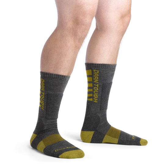 Gray socks with yellow accents worn by a person on a white background