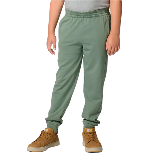 Person wearing light green sweatpants with brown shoes on a white background