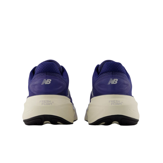 Pair of purple running shoes with beige soles on a white background