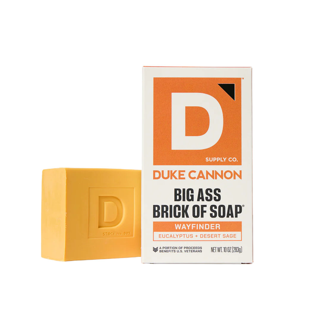 Yellow-orange soap brick beside its box on a white background