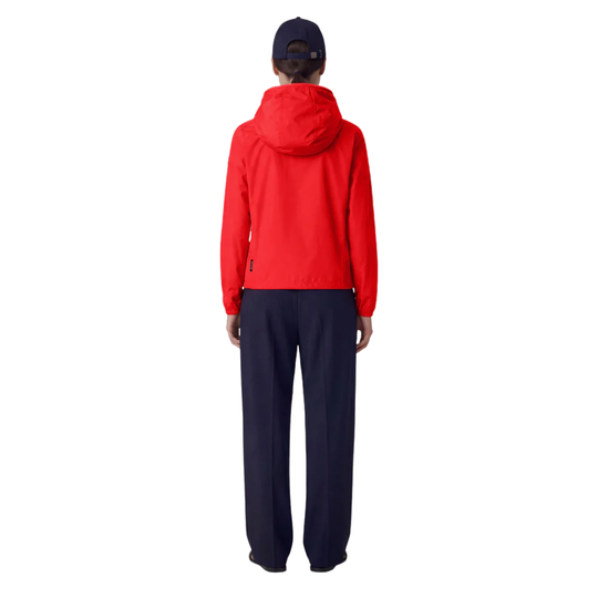 Person wearing a red jacket and navy pants on a white background