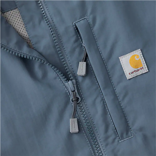 Close-up of a blue jacket with a Carhartt logo on a gray background
