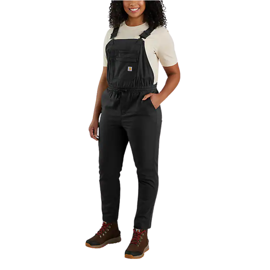 Person wearing black overalls and hiking boots on a white background