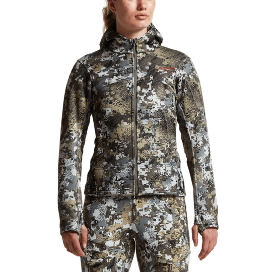 Person wearing a camouflage jacket and pants on a white background