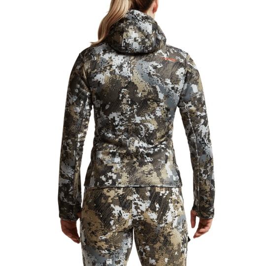 Camouflage jacket and pants worn by a person on a white background