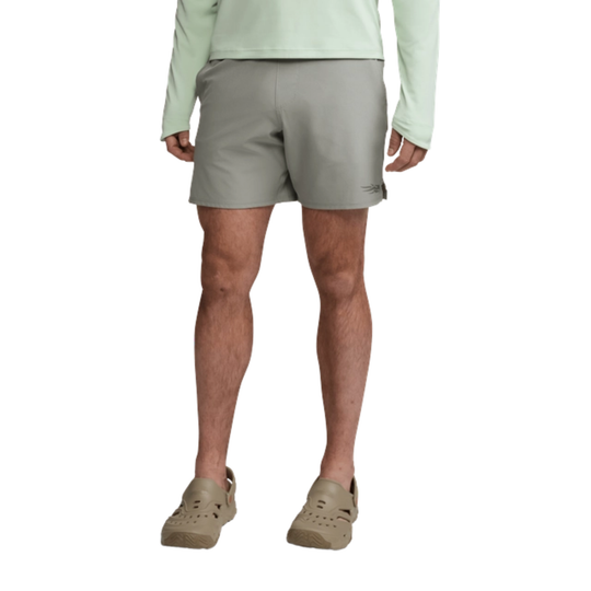 Person wearing light green shirt and gray shorts on a white background