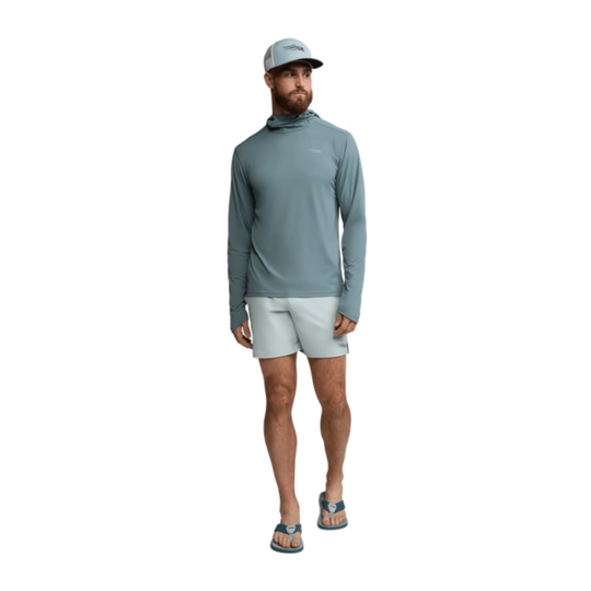 Man wearing a gray long-sleeve shirt and light gray shorts on a white background