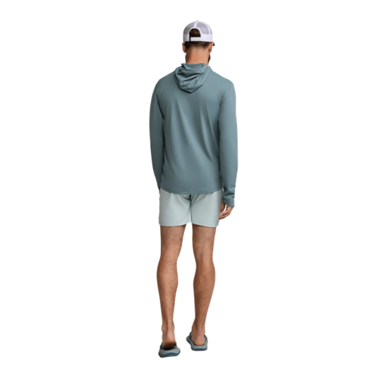 Person wearing a teal hoodie and light gray shorts on a white background