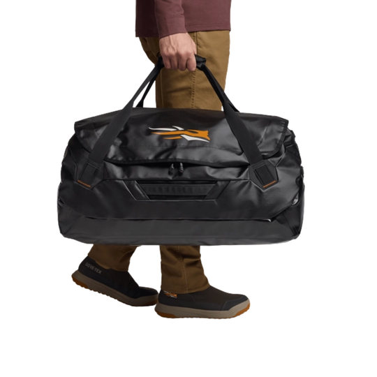 Person holding a black duffel bag with a brand logo on a white background