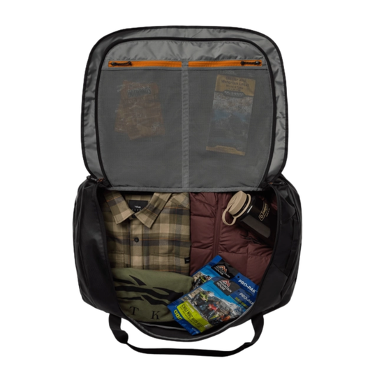 Open backpack with clothes and a map inside on a white background