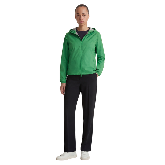 Person wearing a green jacket and black pants on a white background