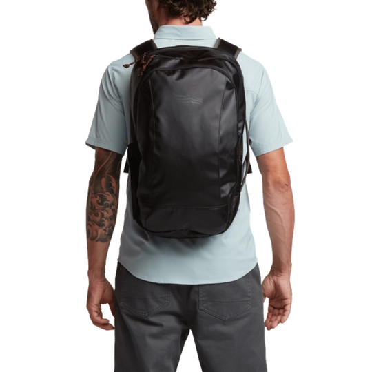 Person wearing a black backpack on a white background