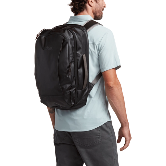 Man wearing a black backpack on a white background
