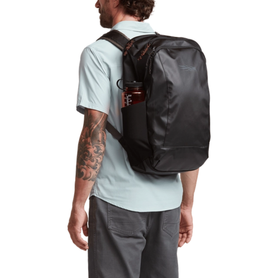 Man wearing a black backpack with a white background