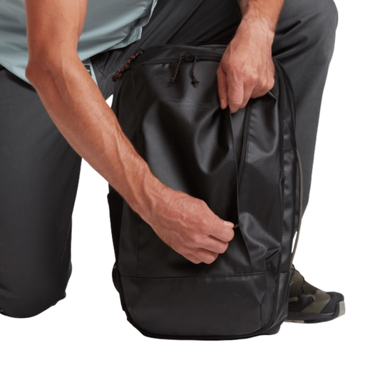Person holding a black backpack with a white background