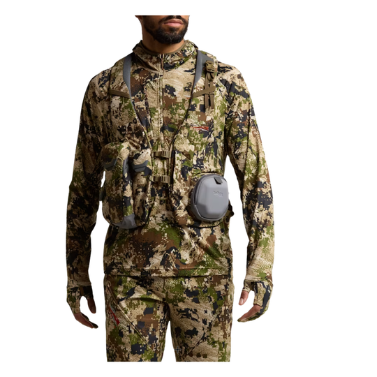 Person wearing full camouflage hunting gear with a white background