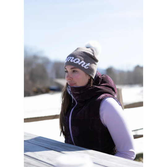 Person wearing a beanie and vest outdoors on a snowy day