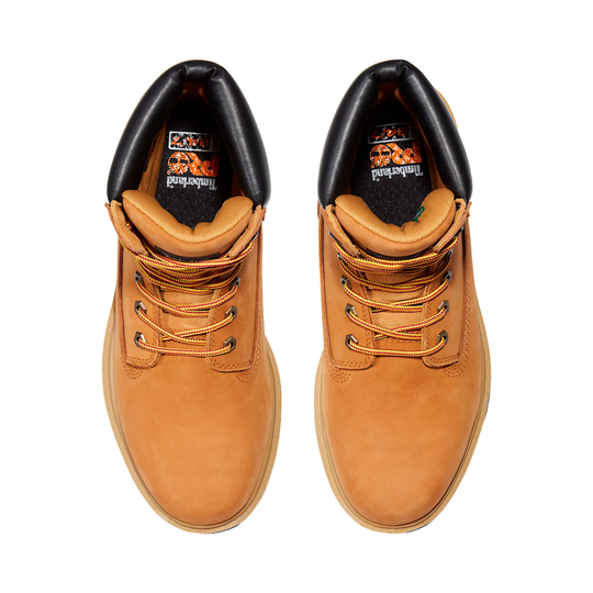 Pair of tan leather boots with black soles on a white background