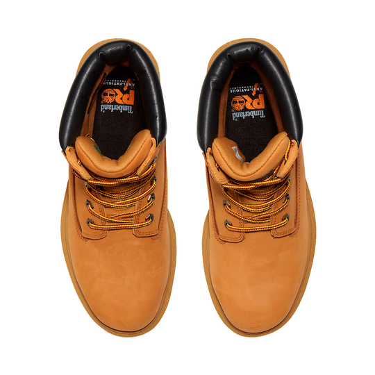 Pair of tan leather boots with black soles on a white background
