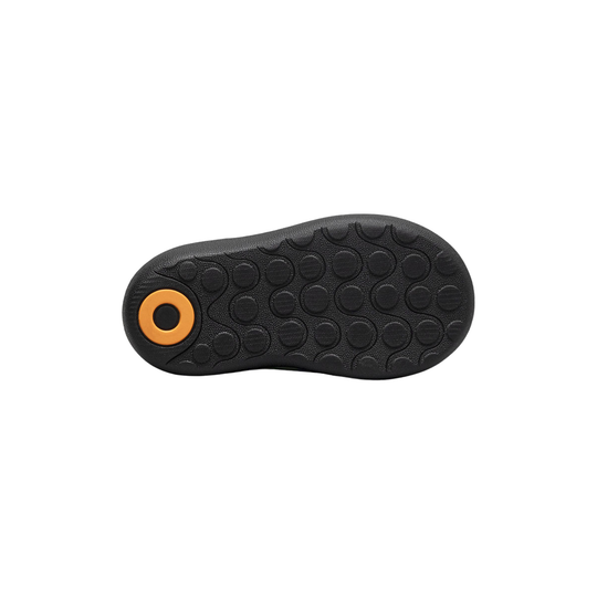 Black shoe sole with orange circular design on a white background