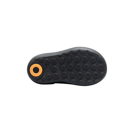 Black shoe sole with a yellow circular feature on a white background