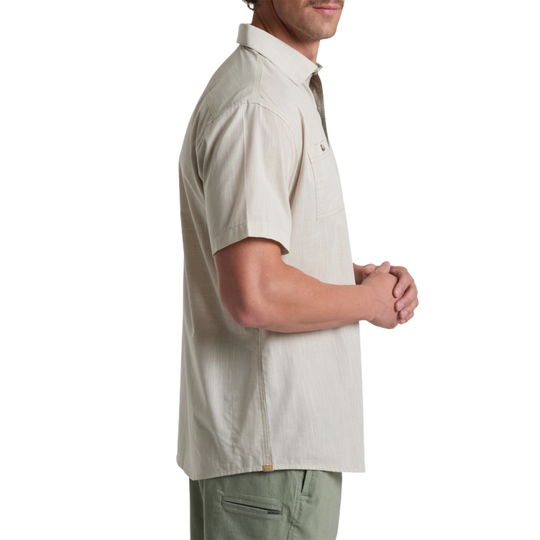 Man wearing a beige short-sleeve shirt on a white background