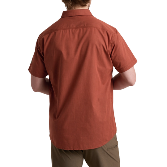 Person wearing a rust-colored short-sleeve shirt on a white background