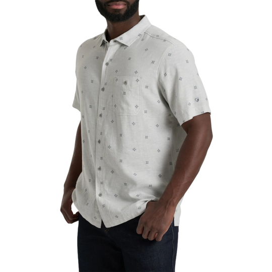 Man wearing a light gray patterned short-sleeve shirt on a white background