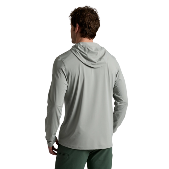 Person wearing a gray hoodie and green pants on a white background