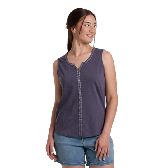 Woman wearing a sleeveless purple top and blue shorts on a white background