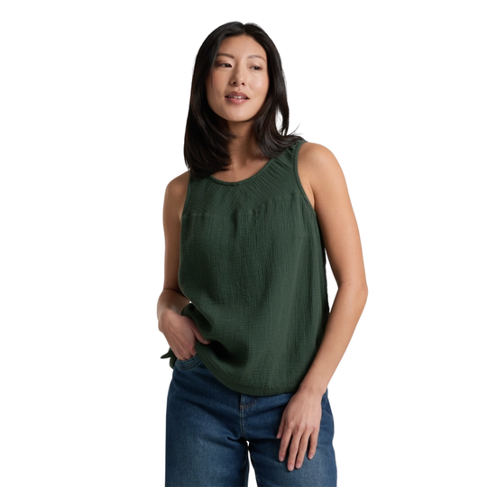 Woman wearing a green sleeveless top and blue jeans on a white background