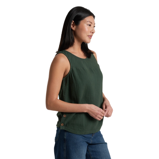 Woman wearing a green sleeveless top and blue jeans on a white background
