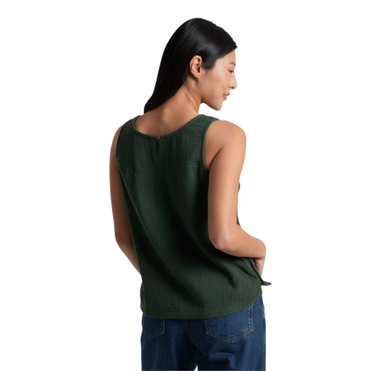 Woman wearing a green sleeveless top and blue jeans on a white background