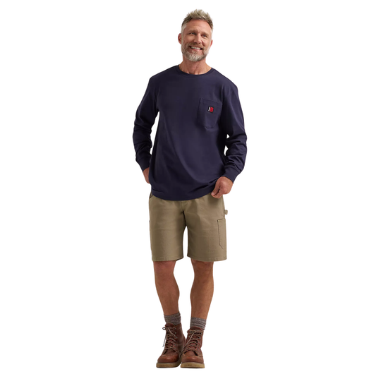 Man wearing a navy long-sleeve shirt with a red logo and beige shorts on a white background