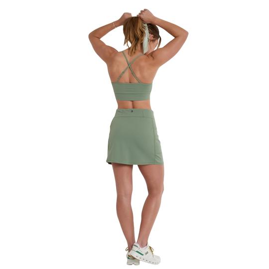 Woman wearing a green athletic outfit on a white background