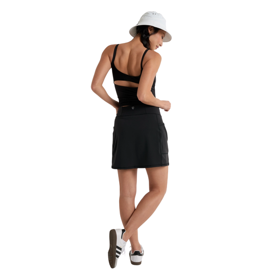 Woman wearing a black dress and white hat on a white background