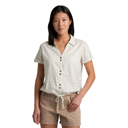 Woman wearing a white patterned shirt and beige shorts on a white background
