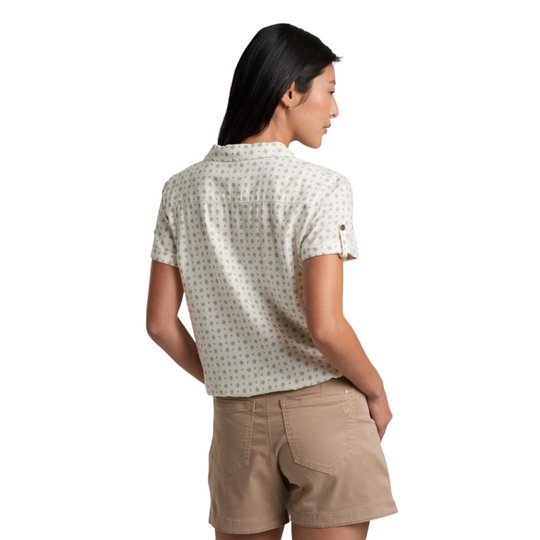 Woman wearing a patterned shirt and beige shorts on a white background