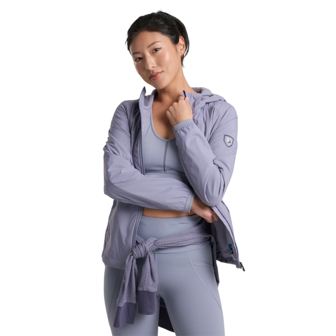 Woman wearing a light purple athletic jacket and leggings on a white background