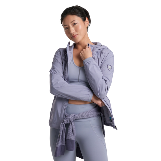 Woman wearing a light purple athletic jacket and leggings on a white background