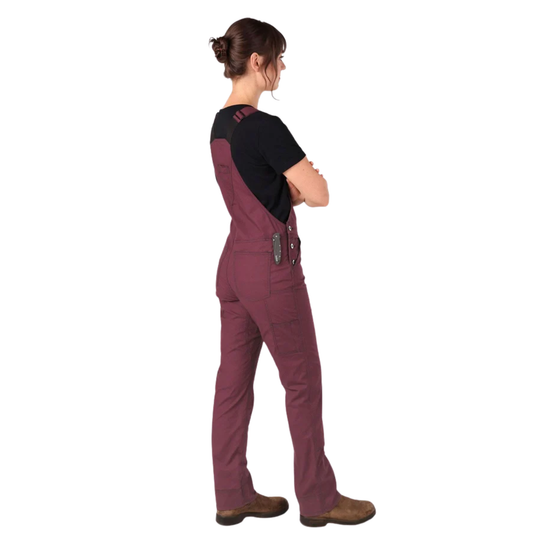 Person wearing a maroon bib overalls with a black shirt on a white background