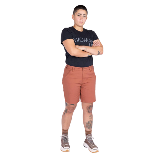 Person wearing a black t-shirt with 'WOMAN' printed on it and brown shorts on a white background