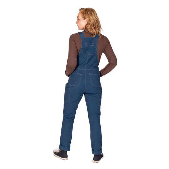 Woman wearing blue denim overalls over a brown long-sleeve shirt, shown from the back on a white background