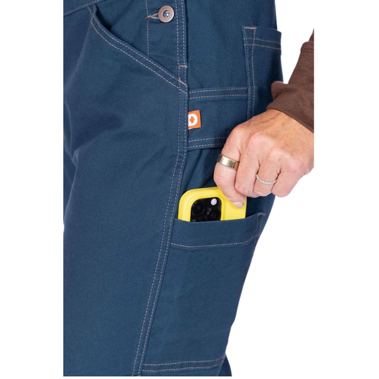 Blue work overalls with chest pockets, holding a yellow phone in the side pocket